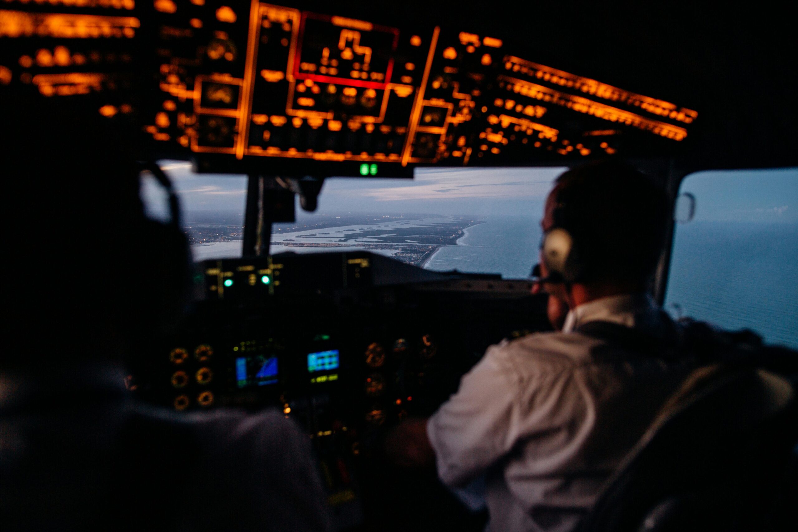 Anonymous pilots in aircraft cockpit flying over sea